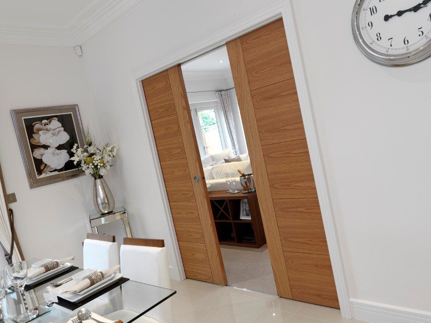 Wooden pocket doors separating a living room and dining room in a modern home
